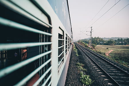 Perspective view of an Indian train coach window from while it is running with a photographer holding the camera outside thumbnail