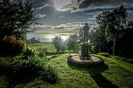 man concrete statue on green grass lawn during daytime thumbnail