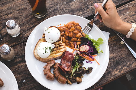 Eating high protein brunch with poached eggs, beans and bacon thumbnail
