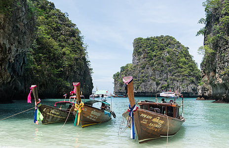 three brown boats on body of water thumbnail