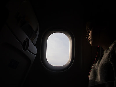 woman sitting in airplane beside window thumbnail