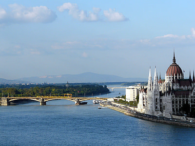brown and white dome building surrounded by body of water near bridge under blue sky at daytime thumbnail