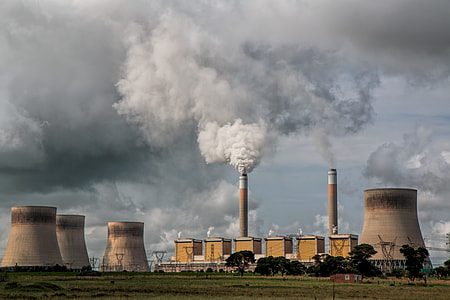 power plant with chimney under grey clouds thumbnail