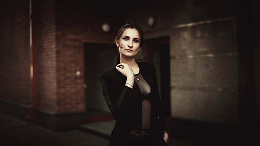 woman wearing black blazer standing near red building thumbnail