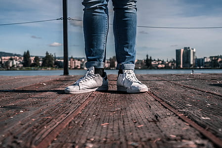 person wearing blue denim jeans and white shoes thumbnail