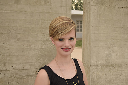 woman standing beside wall thumbnail
