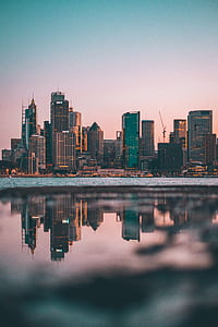 city skyline reflected on calm body of water thumbnail