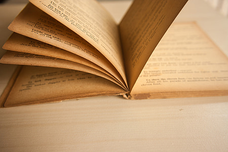 opened book on brown wooden surface thumbnail