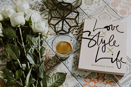 white novel book beside drinking glass thumbnail