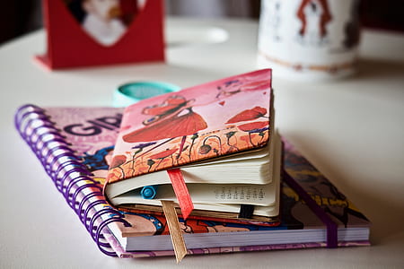 shallow focus photography of two books on white wooden desk thumbnail
