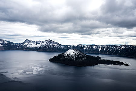 white and black mountain in the middle of body of water thumbnail