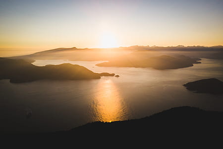 aerial photography of body of water and mountains at golden hour thumbnail