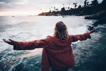 woman facing ocean open arms at daytime thumbnail