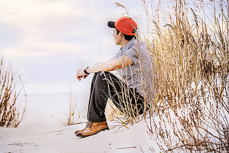 man sitting on snow near body of water thumbnail