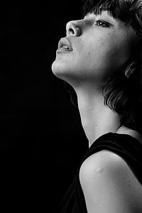 grayscale close-up photography of woman on black background thumbnail