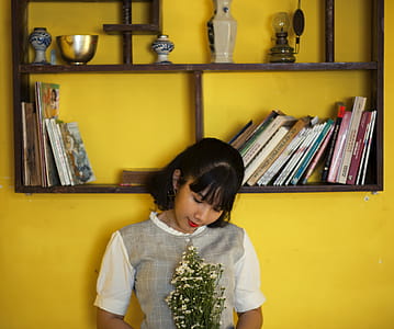 Woman Standing Beside Brown Wooden Shelf thumbnail