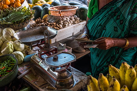 person holding money in front of balancing scale inside market thumbnail