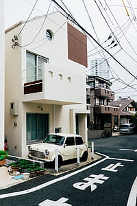 white MINI Cooper parked beside white building thumbnail