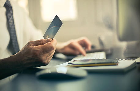 Man using a credit card to pay bills inside an office thumbnail