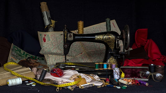 black treadle sewing machine surrounded by assorted items thumbnail