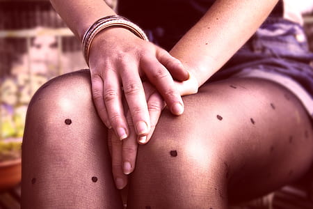 woman sitting on chair while holding her knees thumbnail
