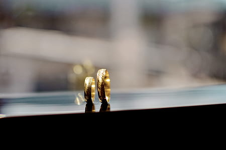 two gold-colored band rings against glass thumbnail