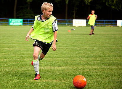 two boys playing soccer during daytime thumbnail