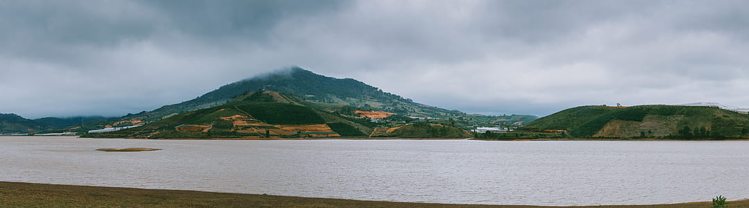 Green Mountain Beside Ocean during Cloudy Day thumbnail