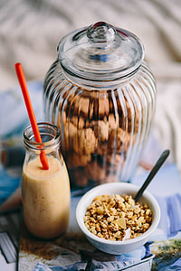 Jar full of walnuts with a fresh healthy shake and musli in a bowl thumbnail