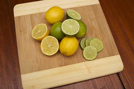sliced lemons and limes on brown chopping board thumbnail