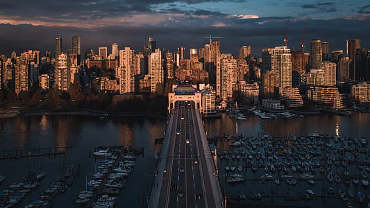 city buildings near boats and road during daytime thumbnail