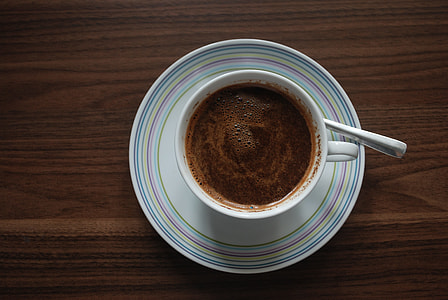 coffee filled white ceramic mug on white ceramic saucer thumbnail