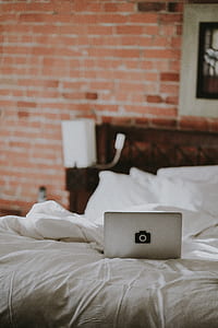 gray laptop on white bed sheet thumbnail