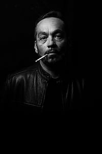 man biting cigarette in grayscale photo thumbnail