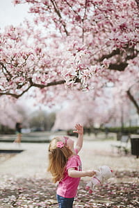 girl standing under flowering tree thumbnail