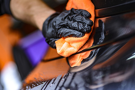 person wearing black glove holding orange textile thumbnail