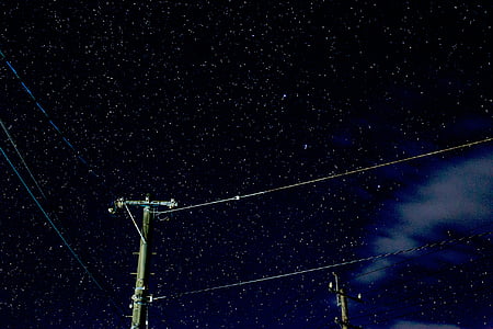 gray wooden antenna post under black sky thumbnail