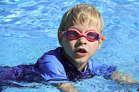 boy wearing swimming goggles in body of water at daytime thumbnail