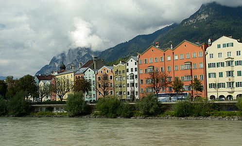 assorted-color painted buildings near road and body of water thumbnail
