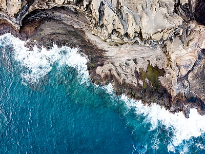 bird's eye view photography of cliff and body of water thumbnail