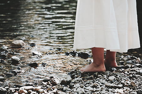 person wearing white skirt while standing near body of water thumbnail