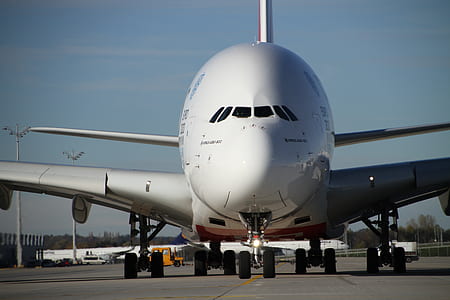 white airplane on grey concrete road under blue sky thumbnail