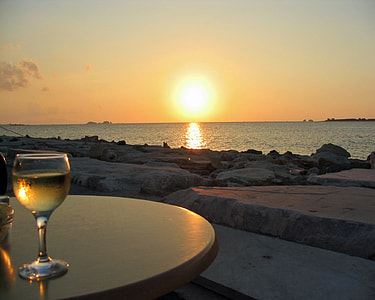 clear wine class on the beige plastic table at sun set thumbnail