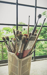 assorted-color paintbrush inside white plastic basket thumbnail
