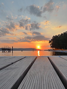 dock above body of water under white clouds during golden hour thumbnail