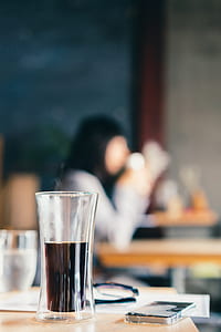 selective focus photo of cylindrical drinking glass with black liquid inside thumbnail