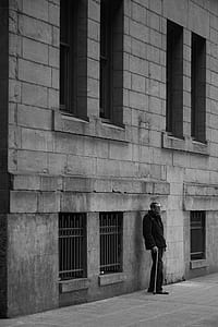 man standing beside wall thumbnail