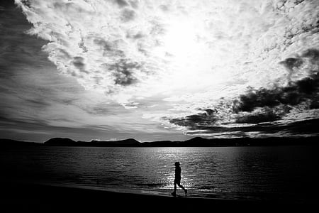 grayscale photo of person walking on seashore thumbnail