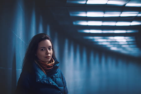 girl standing beside grey wall in a dim lit tunnel thumbnail
