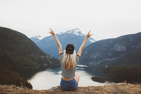 woman sitting enjoying mountain and body of water thumbnail